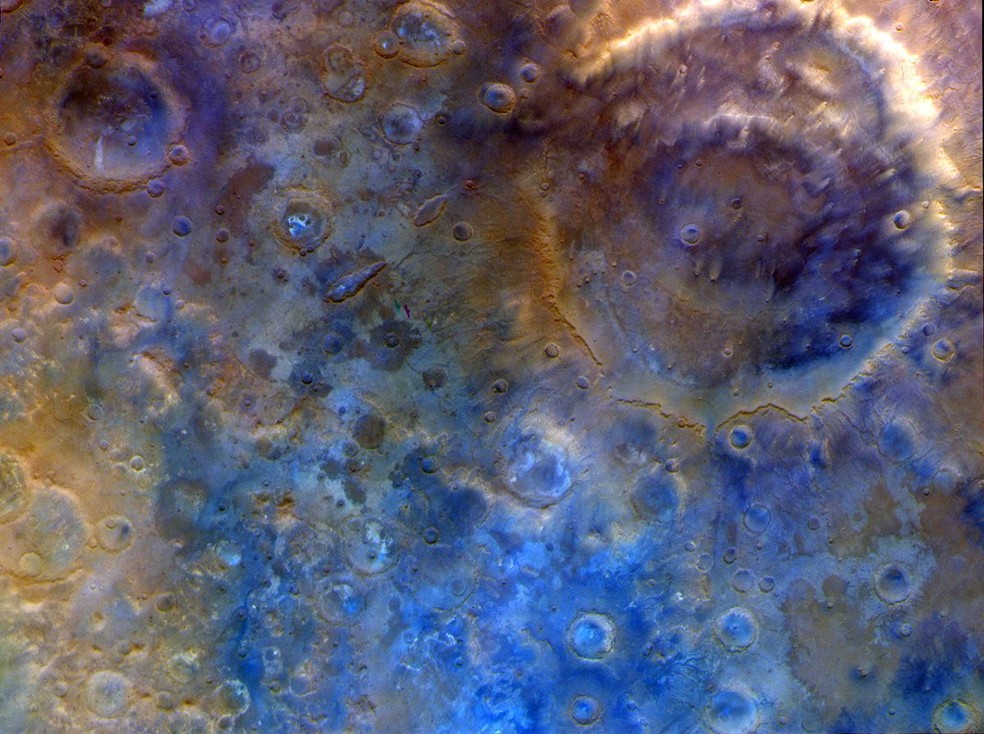 Uma imagem em núcleos falsos de Marte, utilizando dados capturados pela sonda Psyche da NASA durante sua passagem pelo planeta em 15 de maio de 2026. No canto superior direito, está a cratera Huygens, com seus anéis, medindo 470 km de diâmetro duplo — Foto: NASA/JPL-Caltech/ASU
