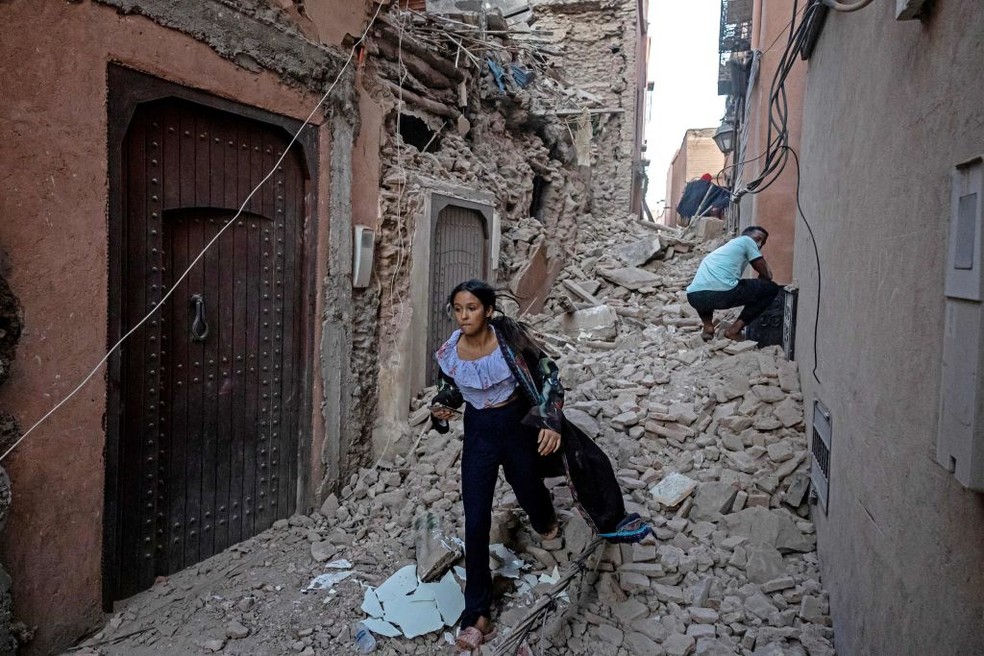 Durante a manhã do dia 9, diversas pessoas voltaram aos escombros que outrora foram suas casas para recuperar seus pertences deixados às pressas na noite anterior — Foto: FADEL SENNA/AFP via Getty Images