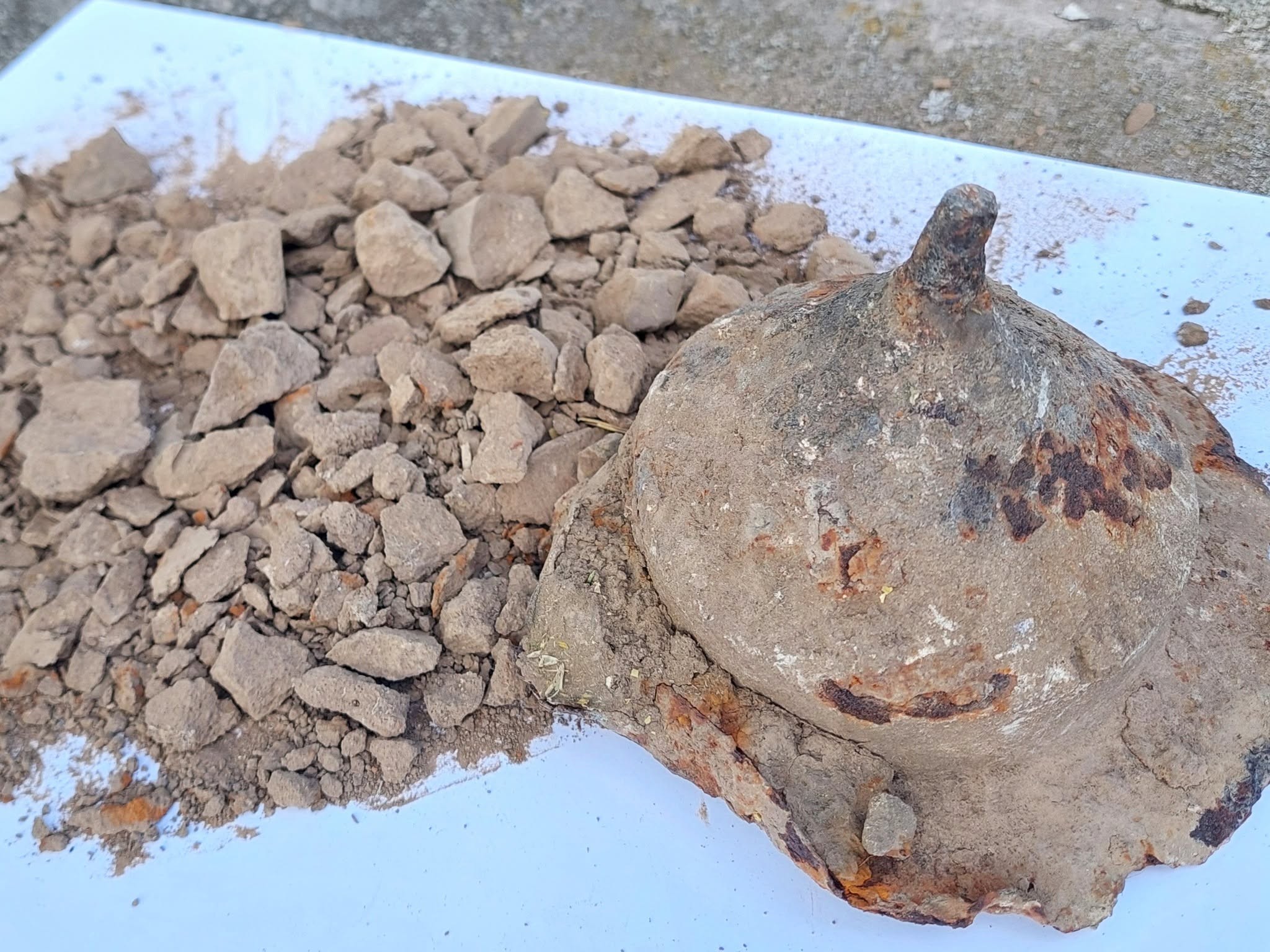 Umbo de escudo antigo com terra e restos cremados encontrado em ferro-velho