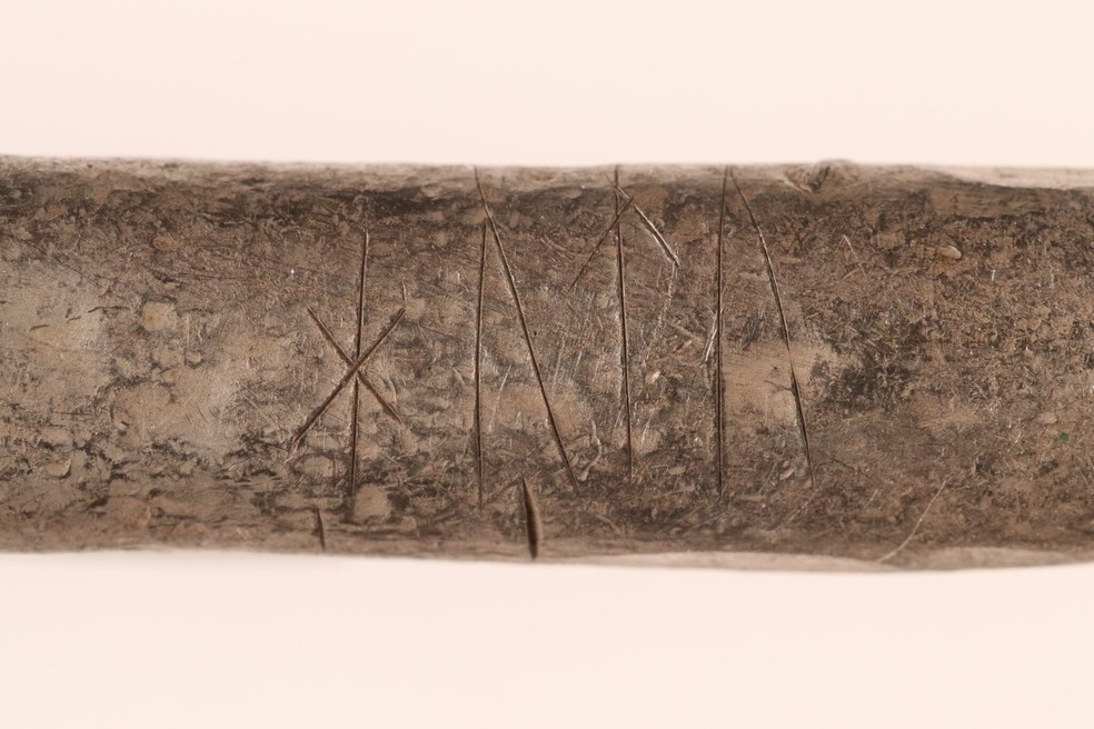 Uma das barras de prata do tesouro possui runas gravadas. Possivelmente está escrito "hutu" e pode ser um nome, a marca de um proprietário ou alguma outra marcação significativa — Foto: Museus do Norte da Jutlândia