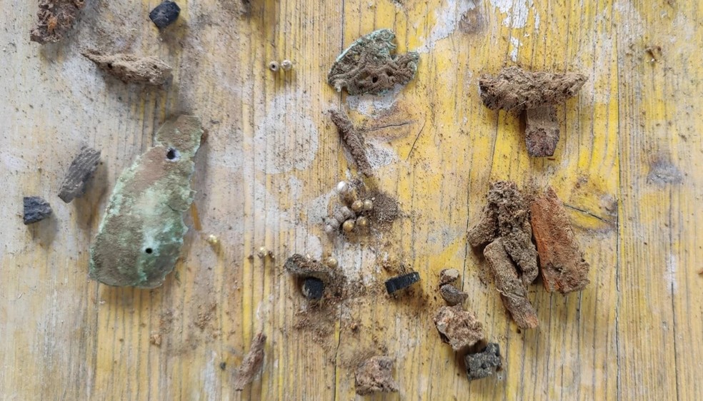 Artefatos como pérolas douradas e fivela de cinto foram encontrados no túmulo — Foto: Divulgação/Joakim Wintervoll