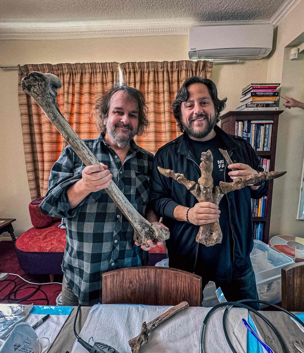 Ben Lamm (à direita) e Peter Jackson (à esquerda), um dos principais colaboradores do projeto, segurando um osso e um pé de moa conservados — Foto: Divulgação/Colossal Biosciences