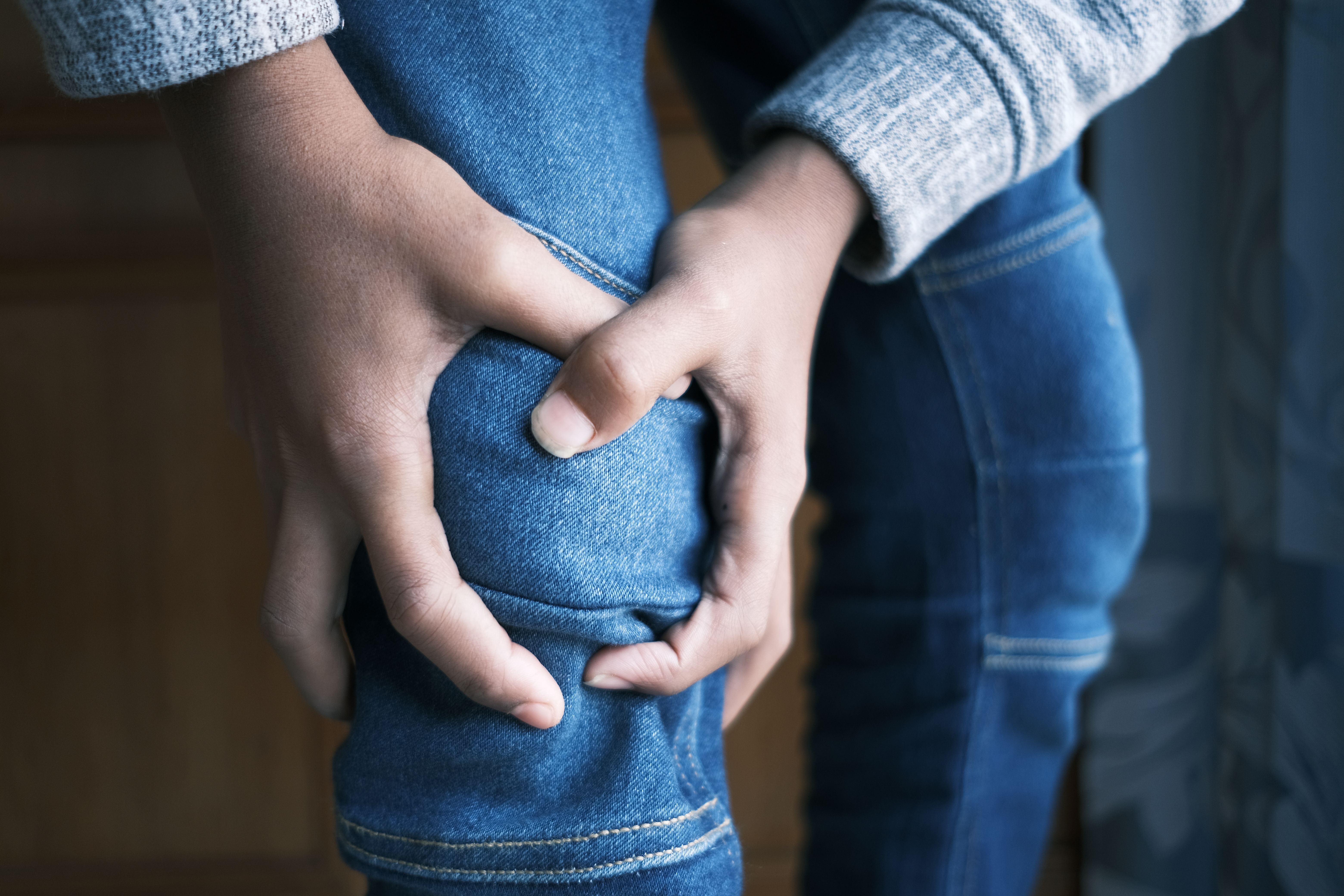 Criança sendo consolada por mãe devido a dor nas pernas