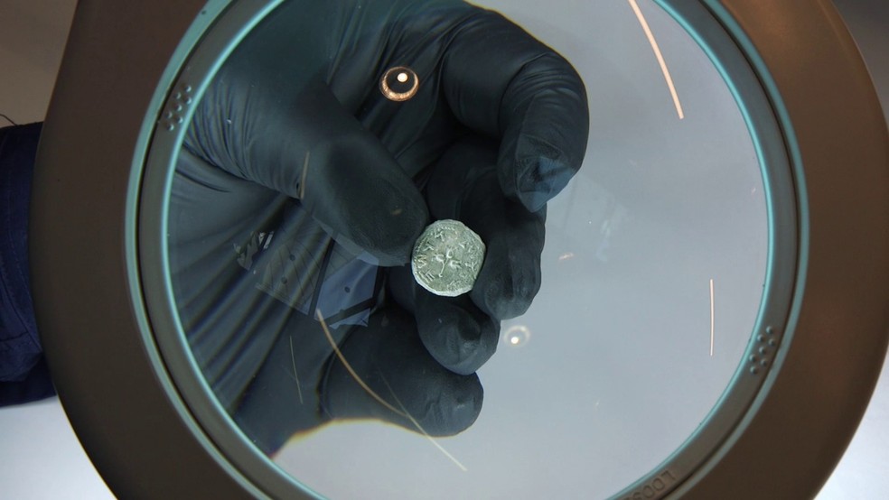 Yaniv David Levy, pesquisador e curador da seção de moedas da Autoridade de Antiguidades de Israel, segurando a moeda  — Foto: Emil Eljam, Israel Antiquities Authority