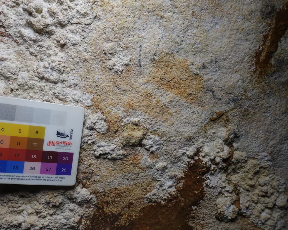 O contorno desbotado de uma mão havia passado despercebido entre pinturas mais recentes de animais e outras figuras — Foto: Nature
