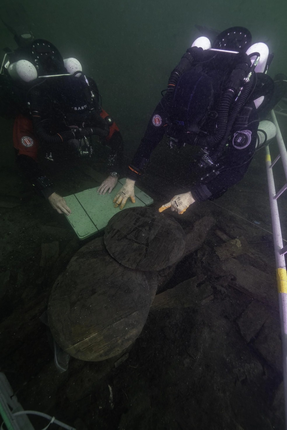 Pesquisadores examinam as cabeças de barris de madeira que foram encontrados no local do naufrágio de Gribshunden — Foto: Divulgação/Brett Seymour