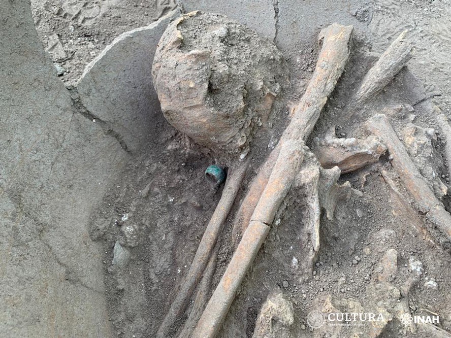 Arqueólogos desenterraram o esqueleto de um jovem maia sacrificado com um grande anel de jade