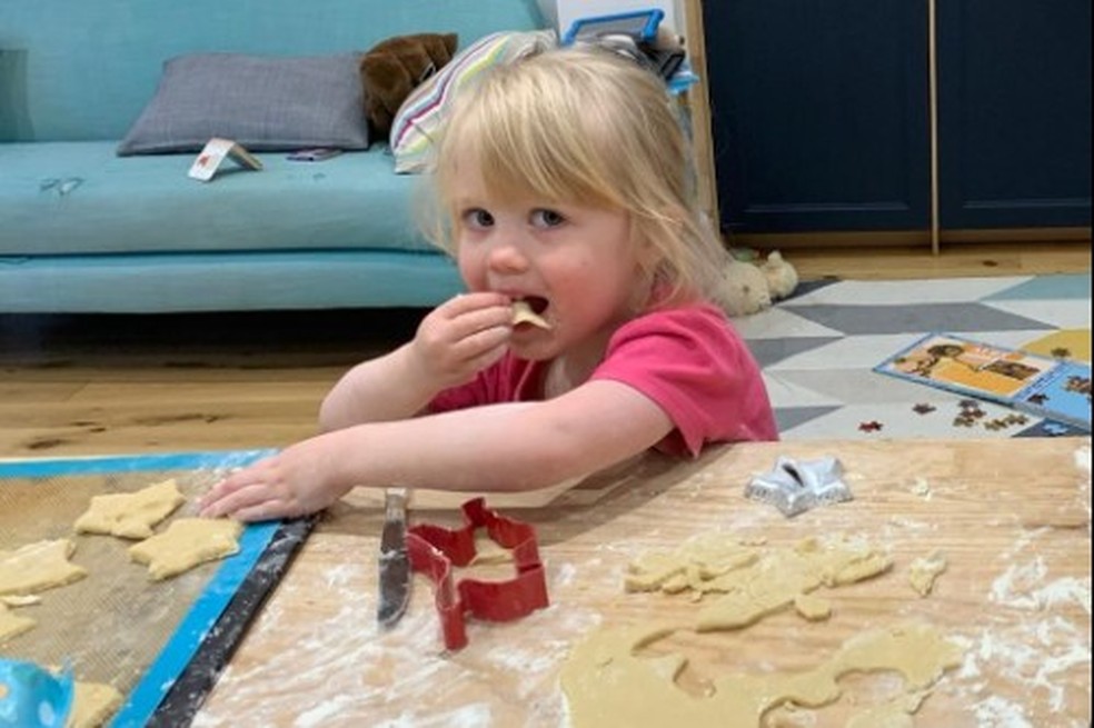 A filha pequena do professor Hoicka, Ada Hersee-Hoicka, de dois anos na foto, comendo massa de biscoito escondida quando pensava que a mãe não estava olhando — Foto: Elena Hoicka