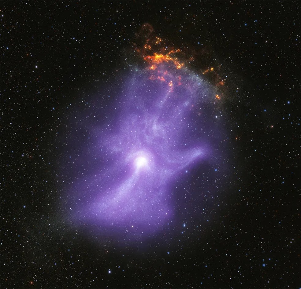 A "mão de Deus"é uma nebulosa de vento de pulsar — Foto: NASA/CXC/Stanford Univ./R. Romani et al. (Chandra); NASA/MSFC (IXPE); Infared: NASA/JPL-Caltech/DECaPS; Image Processing: NASA/CXC/SAO/J. Schmidt)