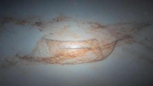 Hubble mostra faixas de poeira cósmica ao redor de galáxia a 60 milhões de anos-luz