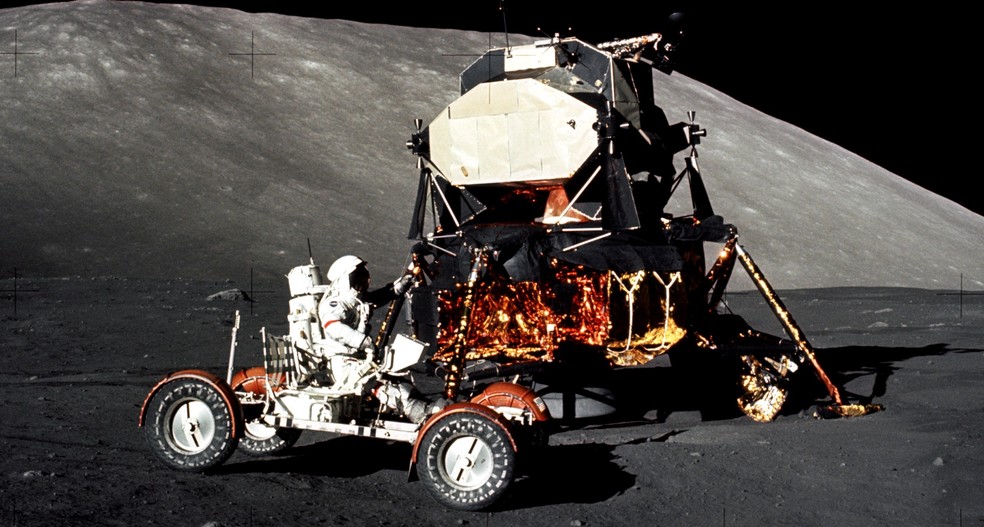 O comandante da missão Apollo 17, Eugene Cernan, dirige o veículo lunar durante a primeira parte da caminhada no local de pouso, Taurus-Littrow. O Módulo Lunar está em segundo plano — Foto: NASA/Harrison Schmitt