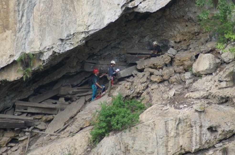 Pesquisadores analisando in loco os enterros — Foto: XIE Peixia/Associação Chinesa de Fotografia Folclórica/Departamento Municipal de Relíquias Culturais de Zhaotong