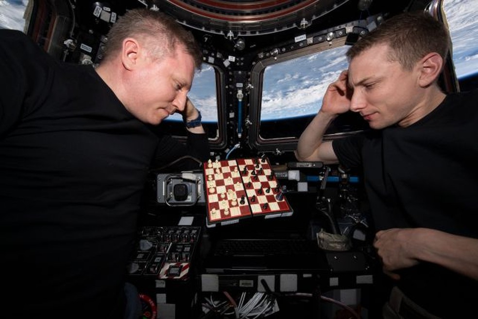 O Comandante da Expedição 69 Sergey Prokopyev de Roscosmos (à esquerda) e o Engenheiro de Voo Woody Hoburg da NASA (à direita) jogando xadrez na cúpula da ISS. — Foto: nasa