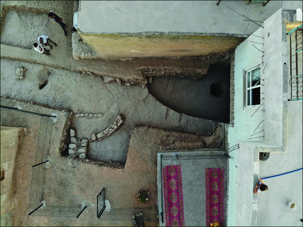 Edifício sendo descoberto entre dois edifícios da vila moderna durante aescavações em Sayburç, Turquia  — Foto: Projeto Sayburç