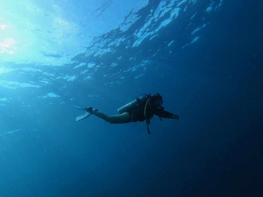 Um mergulhador masculino mergulhando na arte subaquática de uma linha