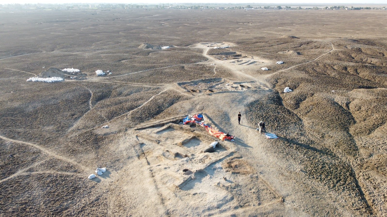 Foto de drone das trincheiras escavadas em 2022. A trincheira mais próxima mostra taverna com um tipo de geladeira de barro, forno e bancadas — Foto: Lagash Archaeological Project