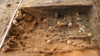Mortos enterrados sentados (esquerda) e pessoas deitadas de lado (metade inferior) com preenchimento denso no centro da cova — Foto: In Terra Veritas/Divulgação