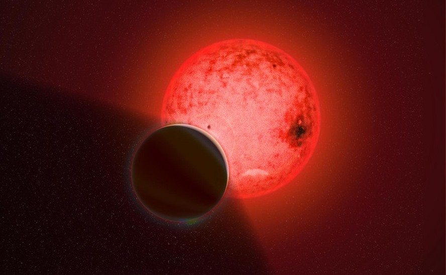Representação artística de um grande planeta gigante gasoso orbitando uma pequena estrela anã vermelha chamada TOI-5205