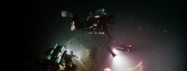 Mergulhadores explorando os destroços no fundo do mar — Foto: Steffen Scholz