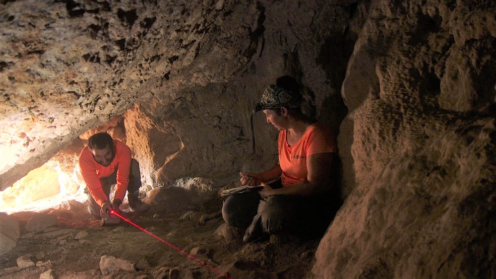 Uriah Amichai e Hagay Hamer mapeiam uma caverna como parte de uma pesquisa no deserto da Judéia — Foto: Emil Eljam, Israel Antiquities Authority