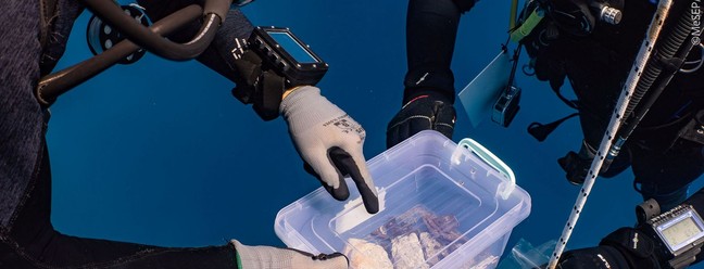 Uma peça decorativa de mármore incrustada na rocha local e sua recuperação por uma equipe de mergulhadores — Foto: G. Issaris