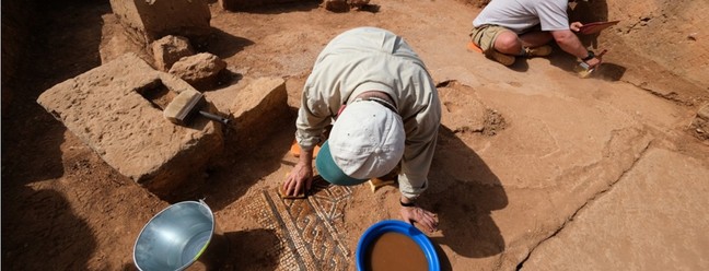Pesquisadores trabalham na limpeza de mosaico próximo à entrada na cisterna — Foto: Piotr Jaworski