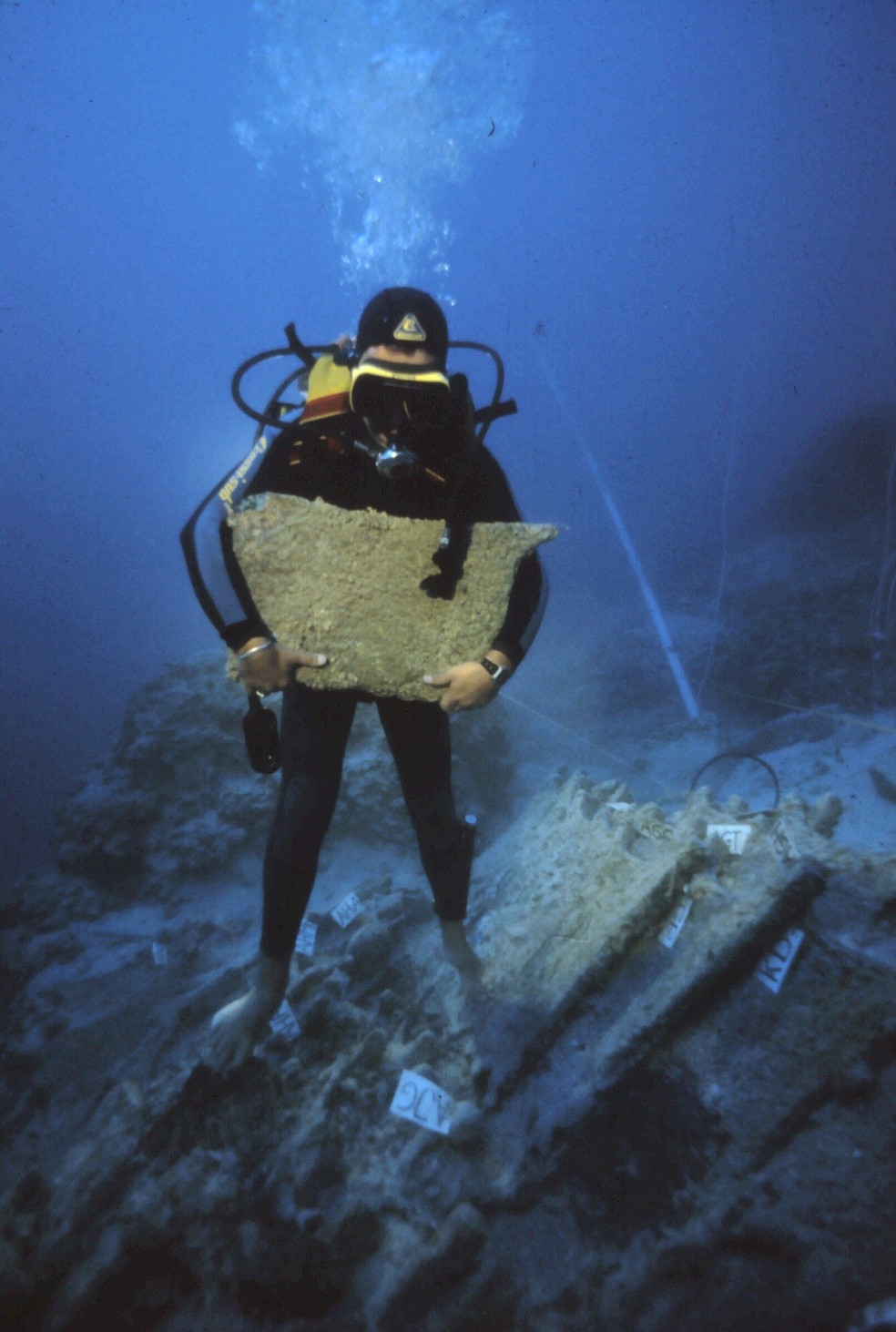 Mergulhador segura placa de cobre descoberta no naufrágio na Turquia  — Foto: Cemal Pulak/Texas A&M University